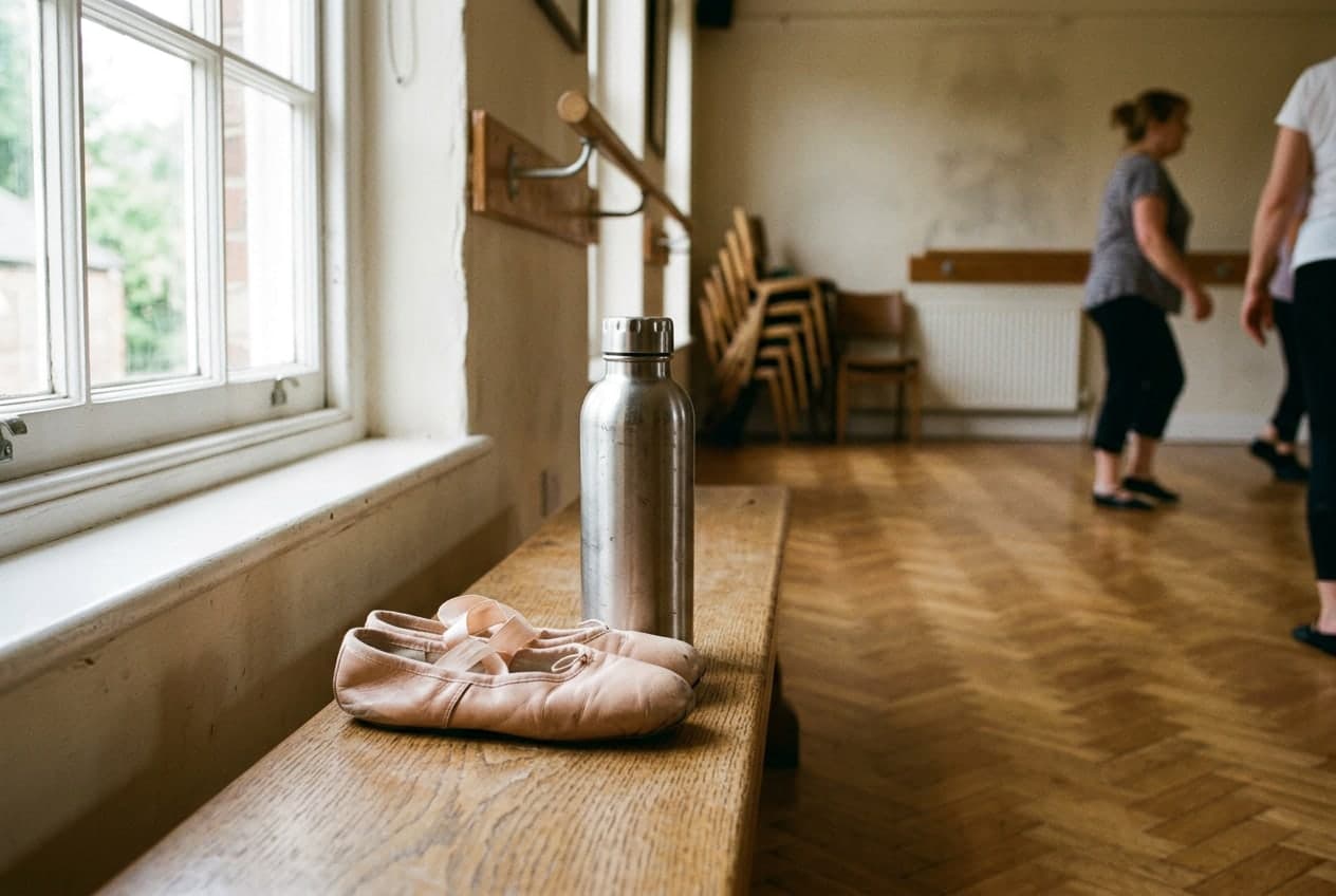 Ballet shoes and a water bottle resting by a sunny window